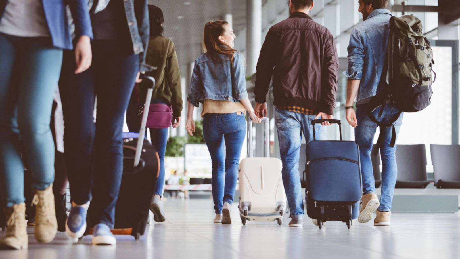 passengers walking in the airport with luggage